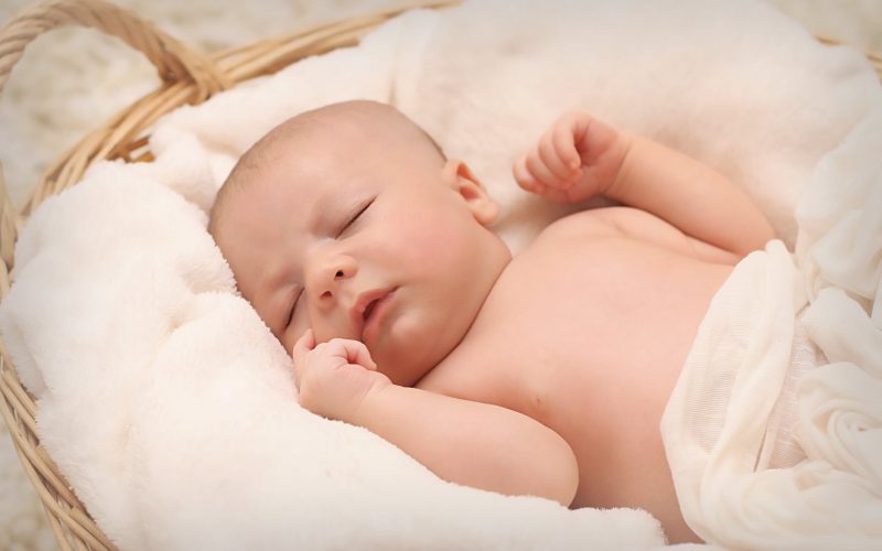 baby sleeping on white cotton