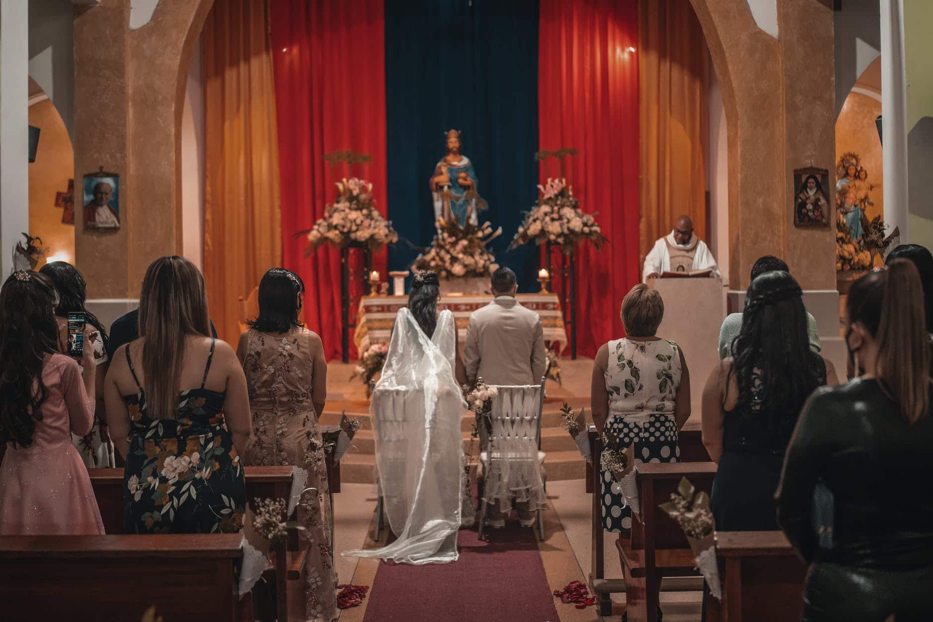unrecognizable newlyweds and guests standing in church hall