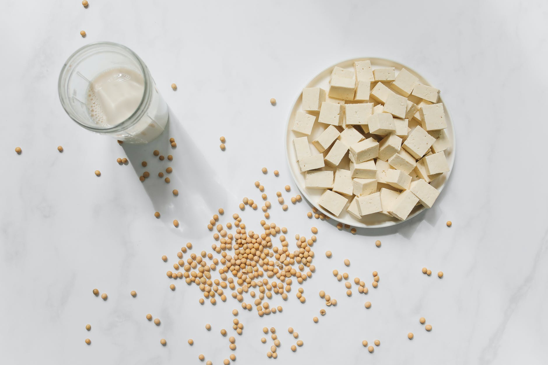 photo of tofu soybeans and soy milk against white background